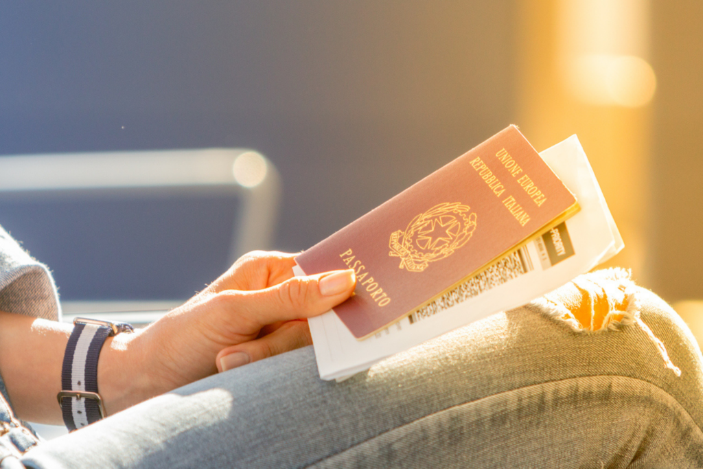Woman sitting and holding an Italian passport