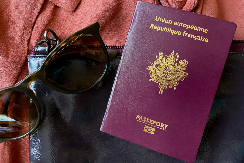 Sunglasses next to a French passport