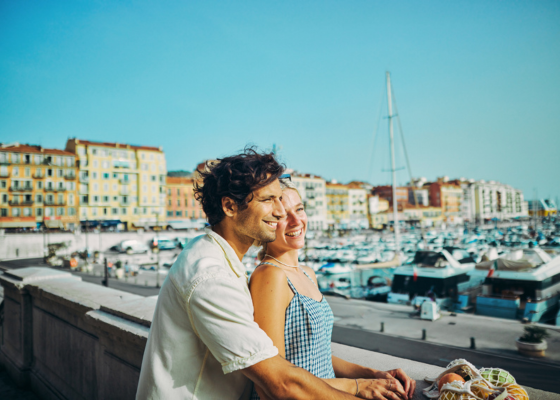 Couple smiling and looking out at boats