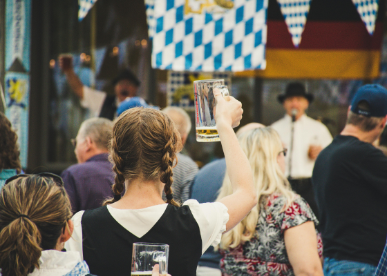 Woman holding a beer glass in her hand in traditional clothing at Octoberfest