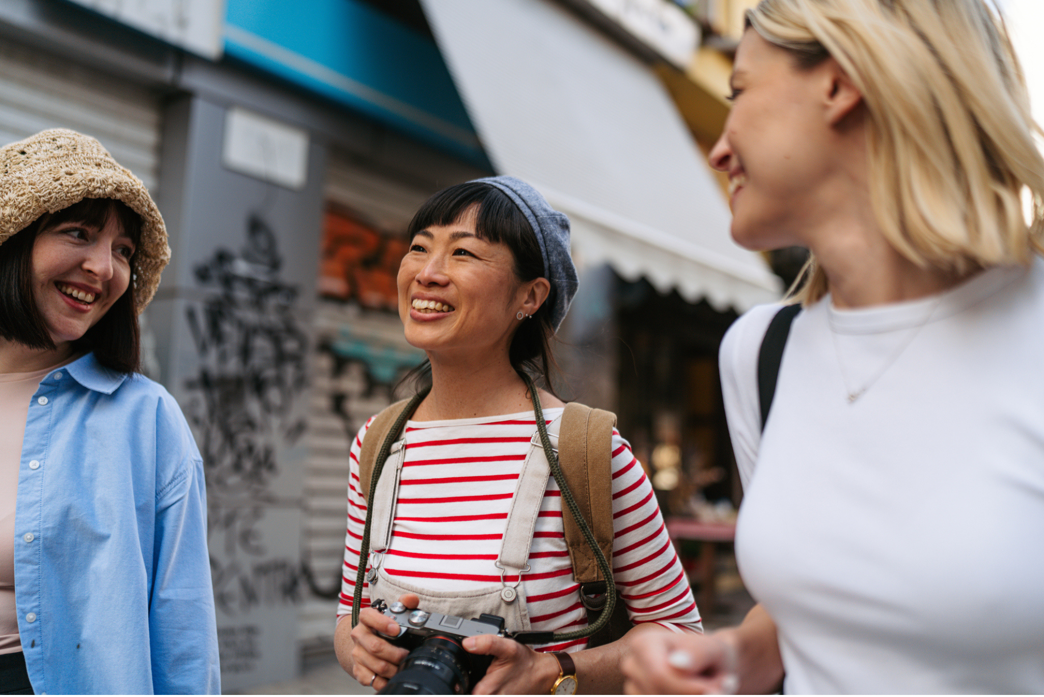 Three women walking through the streets smiling