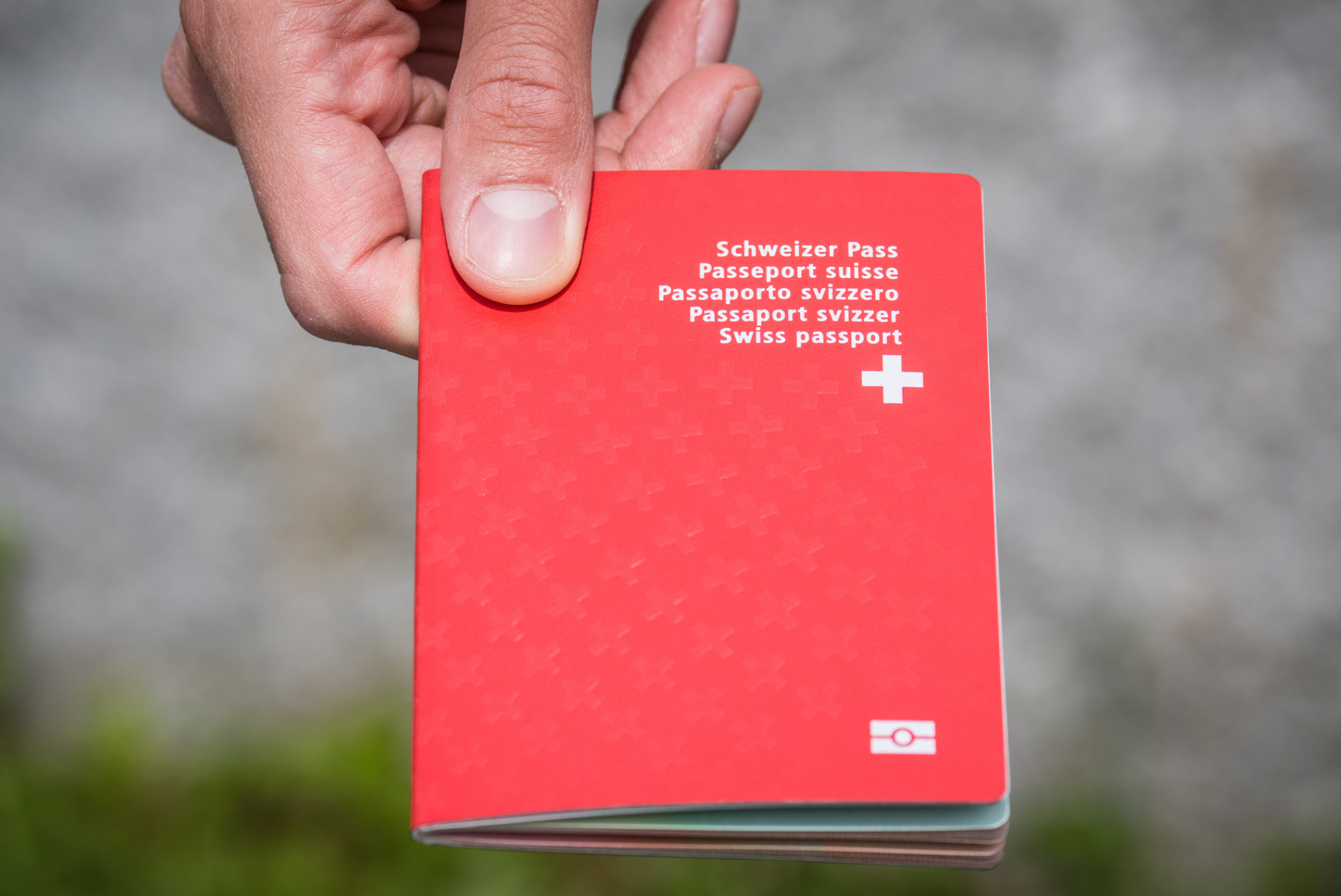 Hand holding a Swiss passport