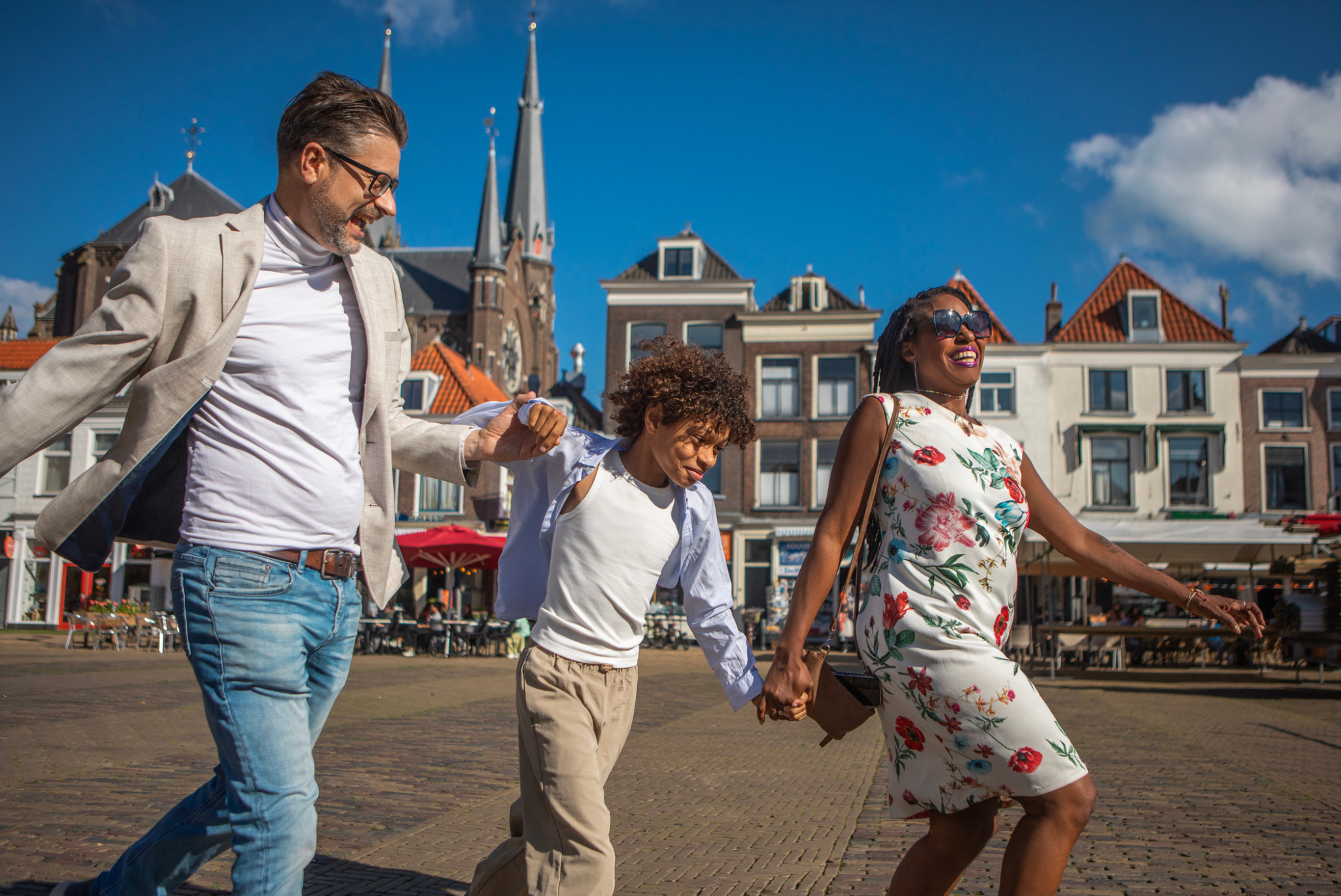 Mixed race family happily skipping down European streets