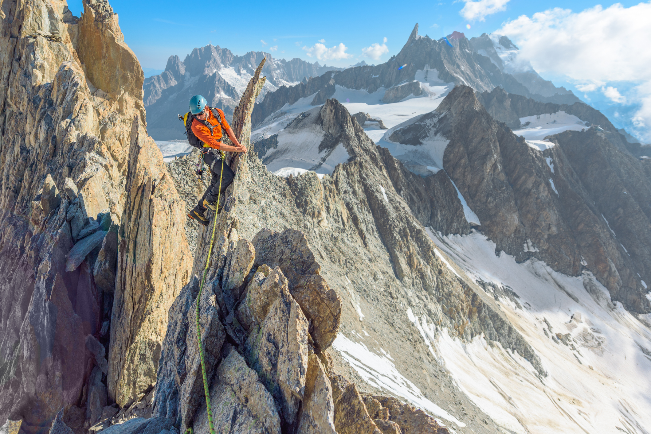 Alpinist traversing a sharp mountain ridge high up in the European Alps on Aiguille d'Entreves route in The Mont Blanc Massif