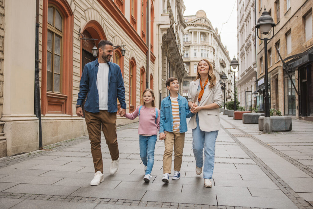 Happy young family on vacation. Parents and kids exploring European city.