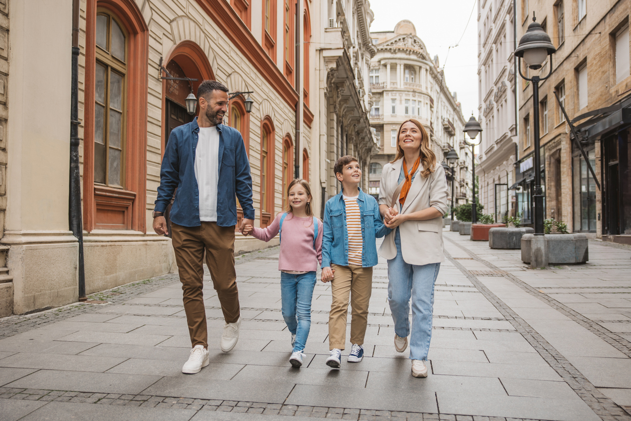 Happy young family on vacation. Parents and kids exploring European city.