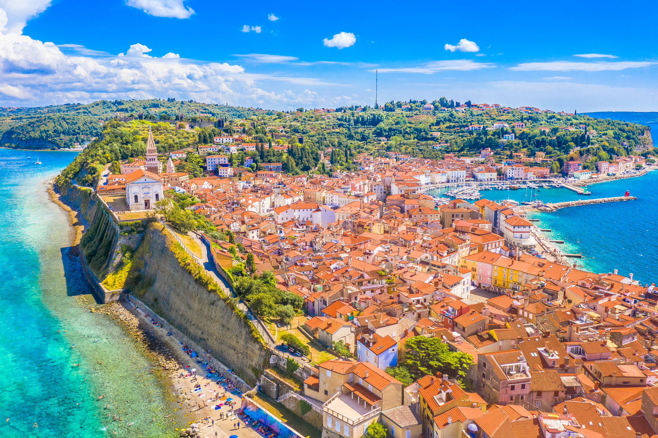 A stunning aerial view of Piran, Slovenia, a picturesque town on the Adriatic coast, showcasing its medieval old town, and seaside charm surrounded by blue Mediterranean waters