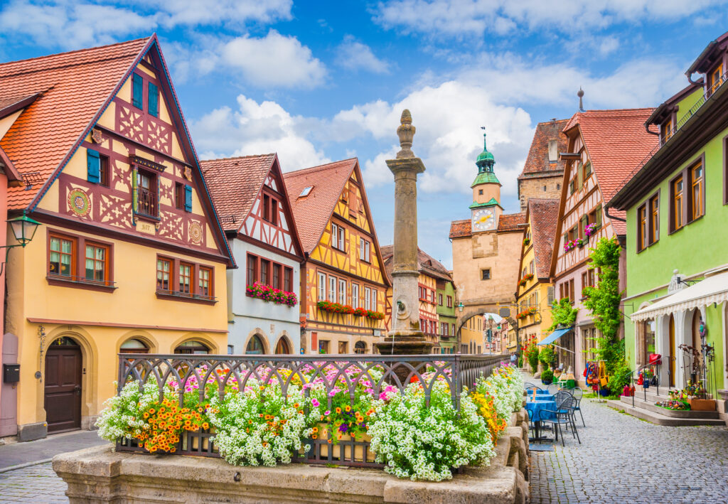 Beautiful postcard view of the famous historic town of Rothenburg ob der Tauber on a sunny day with blue sky and clouds in summer, Franconia, Bavaria, Germany