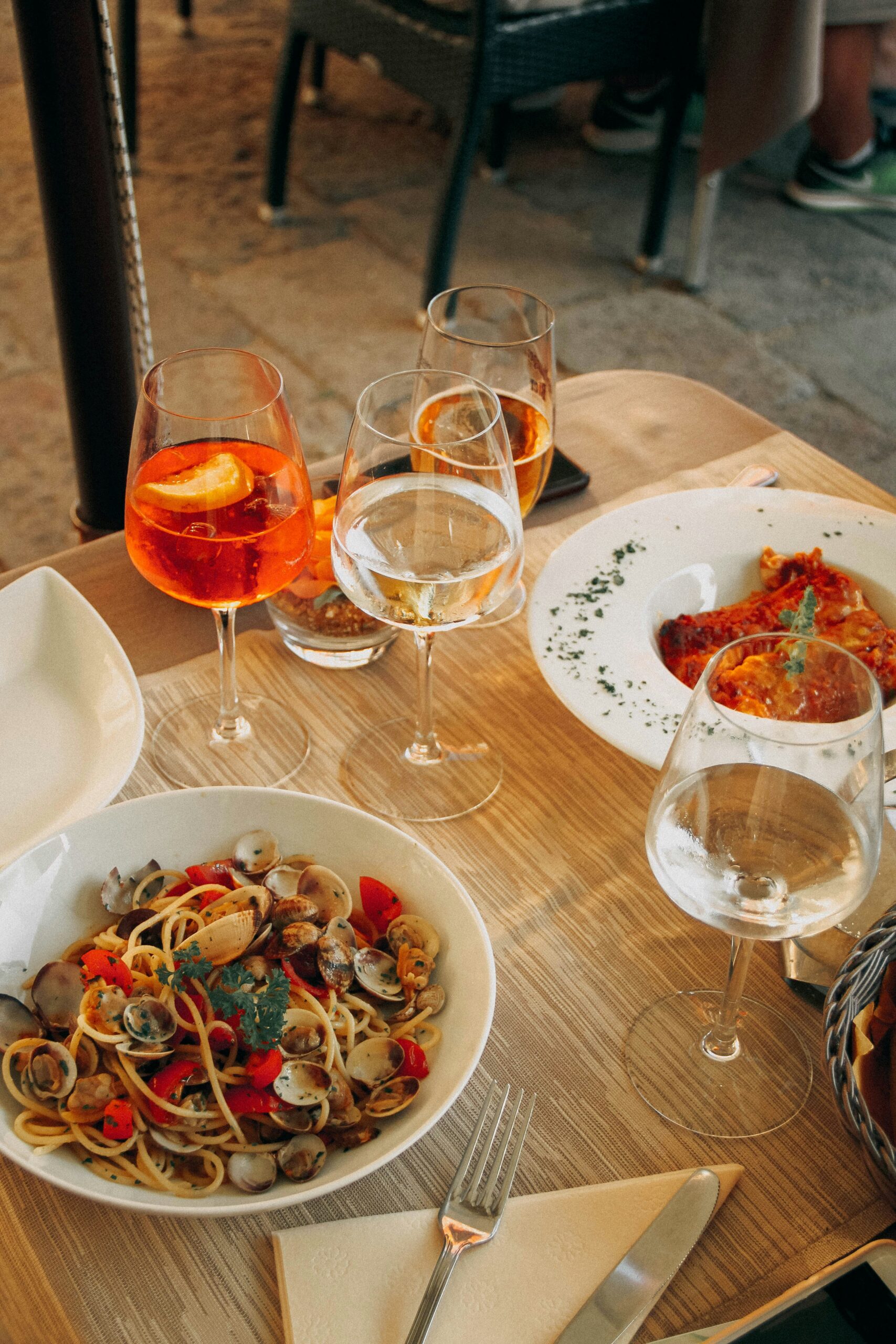 Italian food in white plates with glasses of wine