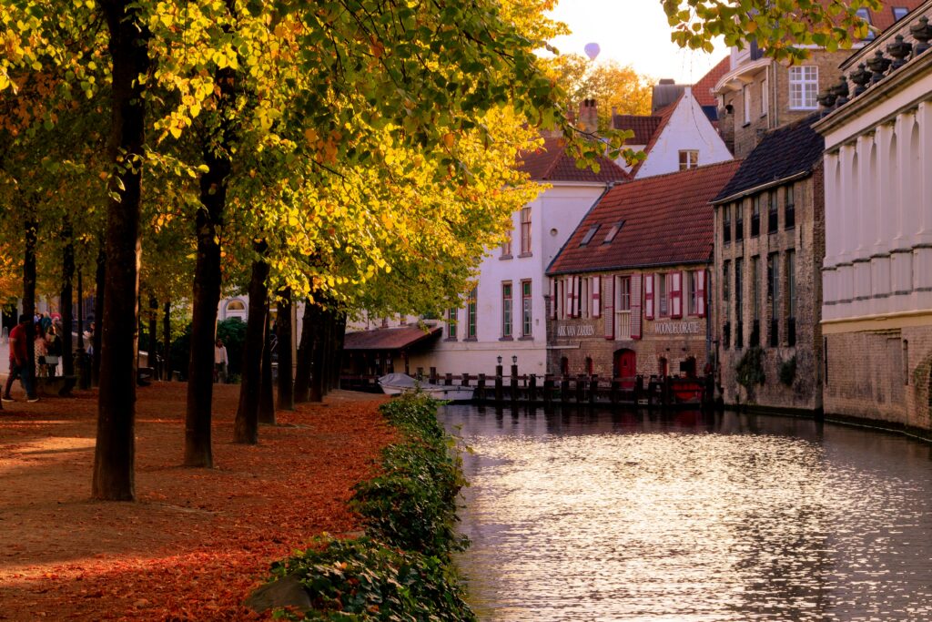 canal in Bruges, Belgium with leaves on the ground in fall