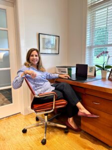 Image of a woman in a chair at a desk, Christine.