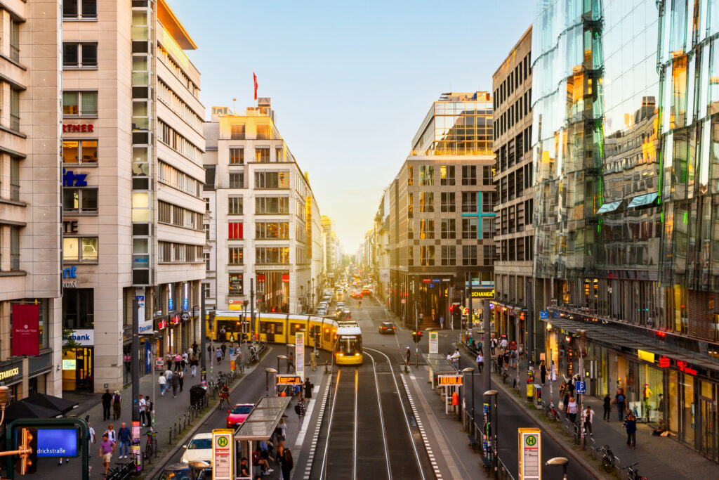 yellow streetcars and car traffic on Berlin Friedrichstrasse at sunset hour