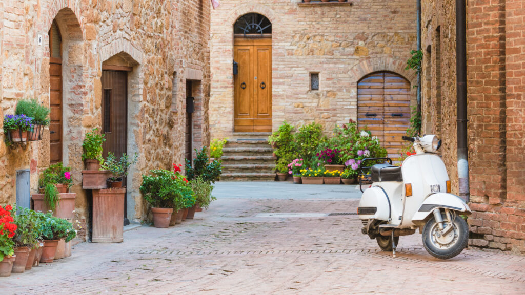 Italian streets in the Tuscan small town with white moped.